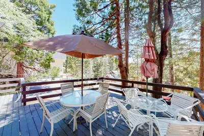 a table and chairs on a deck with an umbrella at Annandale Manor in Lake Arrowhead