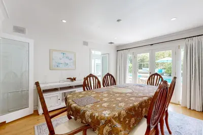 a dining room with a table and chairs and a window at Tullis Charm in Los Angeles