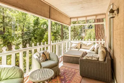 a screened in porch with two chairs and a couch at The Cottage in Lake Arrowhead