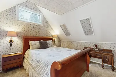 a bedroom with a bed and a desk and a window at The Cottage in Lake Arrowhead