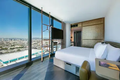 a hotel room with a bed and a large window at Moxy Downtown Los Angeles in Los Angeles