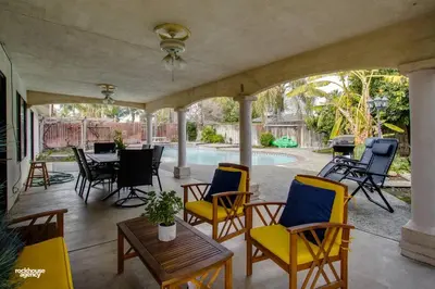 a patio with chairs and a table and a pool at Cozy Hygge Home Centrally Located 2 King Beds in Bakersfield