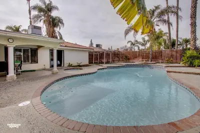 a swimming pool in front of a house at Cozy Hygge Home Centrally Located 2 King Beds in Bakersfield
