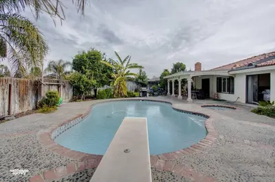 a swimming pool in the yard of a house at Cozy Hygge Home Centrally Located 2 King Beds in Bakersfield