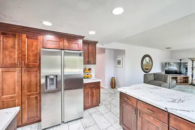 a kitchen with wooden cabinets and a stainless steel refrigerator at Bright California Home with Patio Less Than 1 Mi to Hiking! in Corona