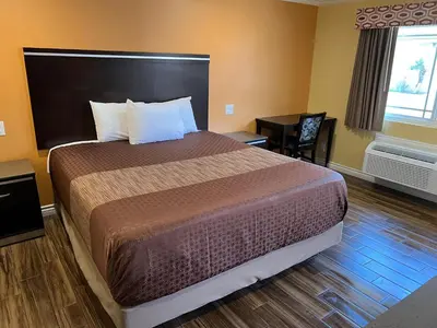 a hotel room with a bed and a desk at Walnut Inn & Suites West Covina in West Covina
