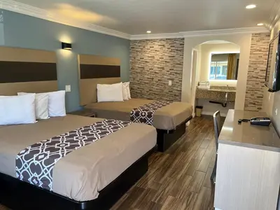 a hotel room with two beds and a bathroom at Walnut Inn & Suites West Covina in West Covina