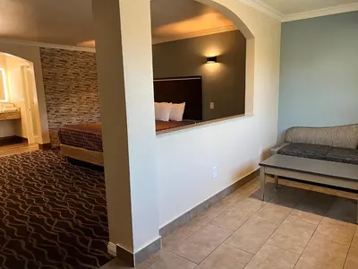 a hotel room with a bed and a mirror at Walnut Inn & Suites West Covina in West Covina