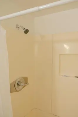 a shower in a bathroom with a glass door at Sherwood Arms Motel in Running Springs
