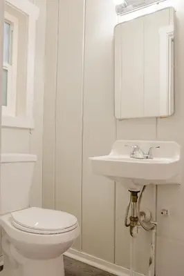 a white bathroom with a toilet and a sink at Sherwood Arms Motel in Running Springs