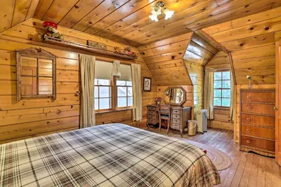 a bedroom in a log cabin with a bed and a desk at Big Bear Lake Cabin about 4 Mi Snow Summit Ski Resort in Big Bear Lake