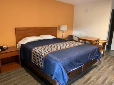 a hotel room with a bed with a blue blanket at Desert Inn Motel in Corona