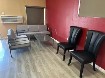 a waiting room with chairs and a couch and a table at Desert Inn Motel in Corona