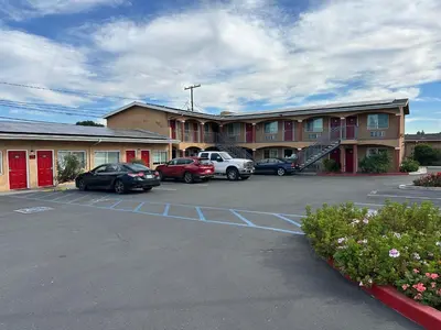 a parking lot with cars parked in front of a hotel at Desert Inn Motel in Corona