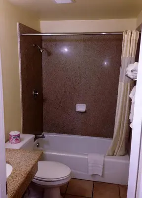 a bathroom with a tub and a toilet and a shower at Downtown Motel 7 in San Bernardino