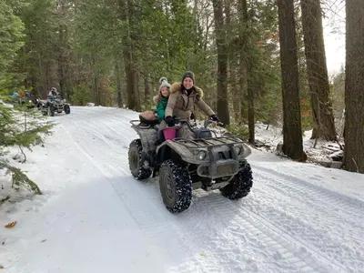 a man and a woman on a four wheeler in the snow at Glamping property in Panorama Heights