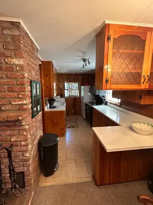 a kitchen with wooden cabinets and a brick wall at Sequoia National Forest Cabin-ATV Ride in Panorama Heights