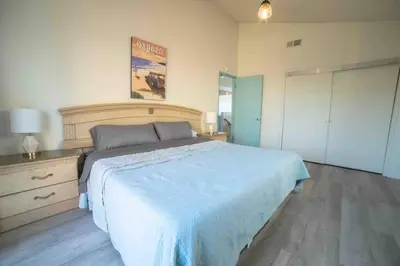 a bedroom with a large bed with a blue blanket at Ocean View / Pool Table / Surfboards / Beach Bikes in Oxnard