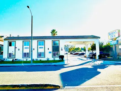 a white building with a gas station in front of it at Casa Blanca Hotel - Cypress, Buena Park in Cypress