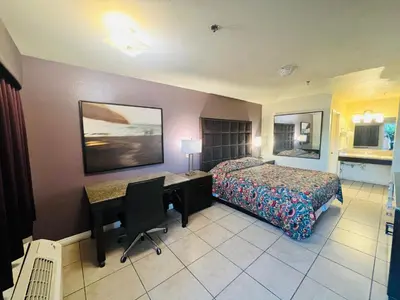a hotel room with a bed and a desk and a computer at Casa Blanca Hotel - Cypress, Buena Park in Cypress