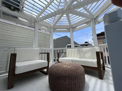 two white chairs and a ottoman on a porch at The Craftsman House in Venice Beach in Los Angeles
