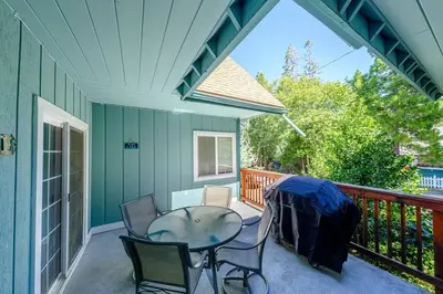 a patio with a table and chairs on a deck at TheDragon's Den Mega Cabin Sleeps 12 in Lake Arrowhead