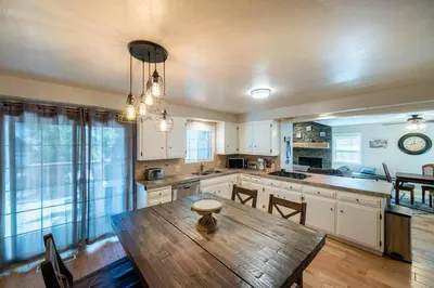 a kitchen with a wooden table and a dining room at TheDragon's Den Mega Cabin Sleeps 12 in Lake Arrowhead