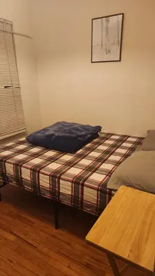 a bed sitting in a room with a table at Nearby Beach House in El Segundo