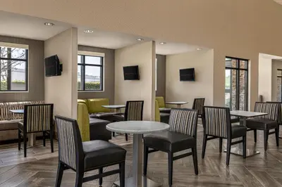 a dining room with tables and chairs and windows at Residence Inn by Marriott Los Angeles Redondo Beach in Redondo Beach