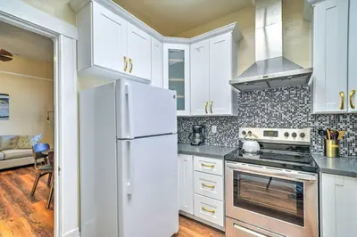 a kitchen with white cabinets and a white refrigerator at Cozy Carpinteria Apartment Walkable Location in Carpinteria