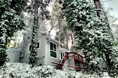 a house with snow on the ground in front of it at Top Town Retreat in Crestline
