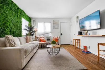 a living room with a couch and a green wall at The Green Haven, 1 Minute Walk to the Beach and Restaurants, King Beds, Beach Amenities in Ventura