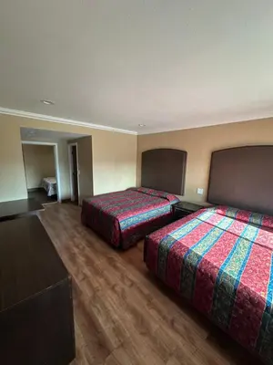 a hotel room with two beds and a television at Stardust inn in Azusa