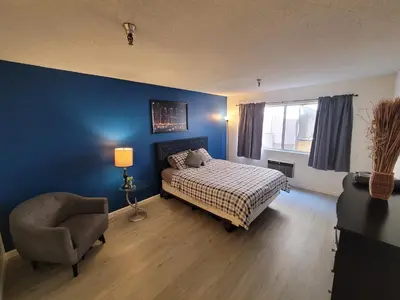 a bedroom with blue walls and a bed and a chair at (A13) Cozy 1 Bedroom Studio with Private Bath in Los Angeles