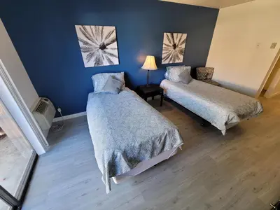 a bedroom with two beds and a blue wall at (B02) Cozy Double Bed Suite in Los Angeles