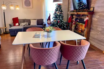 a table and chairs in a living room with a christmas tree at Big Bear Cabin Close to Lake, Trails and Village! in Big Bear Lake