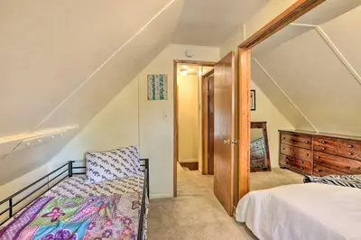 a attic bedroom with a bed and a staircase at Cozy Crestline Cabin, Close to Lakes, Parks! in Crestline