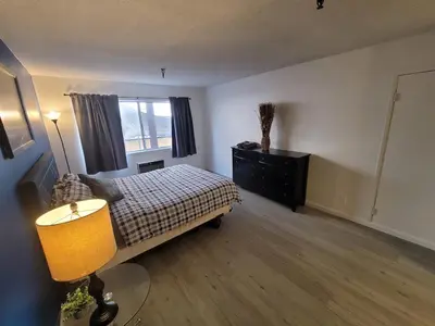 a bedroom with a bed and a dresser and a window at Deluxe Hotel Style Unit in Los Angeles
