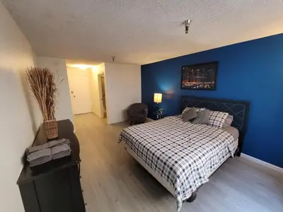 a bedroom with a bed and a blue wall at Deluxe Hotel Style Unit in Los Angeles