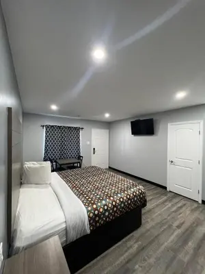 a bedroom with a bed and a tv in it at Sunshine Motel in Long Beach
