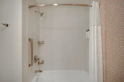 a white bathroom with a shower and a toilet at Fairfield Inn & Suites Lancaster Palmdale in Lancaster