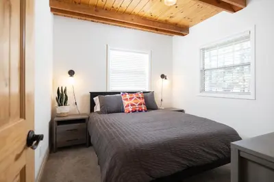 a bedroom with a bed and a window at Bayview Bungalow - Cabin with Hot Tub One Block from Big Bear Lake! in Big Bear Lake