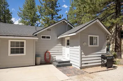 a small white garage with a driveway at Bayview Bungalow - Cabin with Hot Tub One Block from Big Bear Lake! in Big Bear Lake
