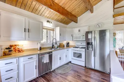 a kitchen with white cabinets and a wooden ceiling at Snow Valley Hideaway Arrowbear Lake Retreat in Arrowbear Lake