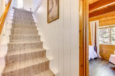 a staircase in a house with a rug on the wall at Snow Valley Hideaway Arrowbear Lake Retreat in Arrowbear Lake