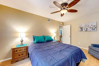 a bedroom with a blue bed and a ceiling fan at Treelands Lodge in Crestline
