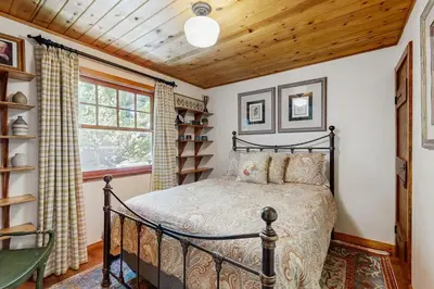a bedroom with a bed and a window at Treetop Cottage in Running Springs