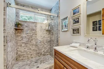 a bathroom with a shower and a sink at Treetop Cottage in Running Springs
