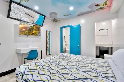a bedroom with a king sized bed and a sink at Royal Hawaiian Inn - Mid City, Los Angeles in Los Angeles