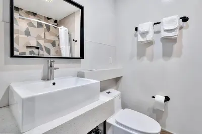 a white bathroom with a sink and a toilet at Royal Hawaiian Inn - Mid City, Los Angeles in Los Angeles